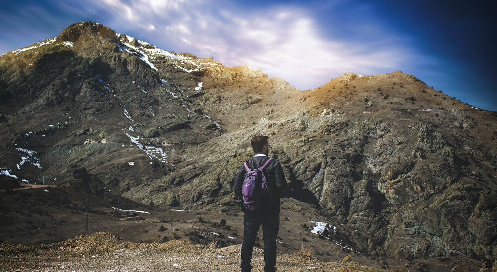 Man Standing Beside Mountain - AdventuRush